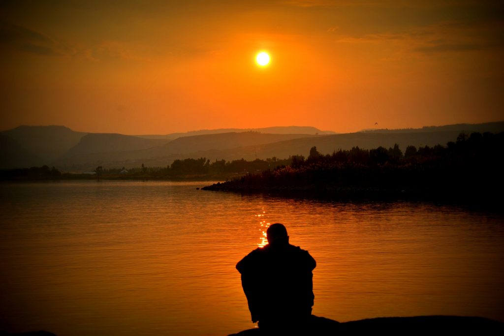 Life transitions, man thinking near water